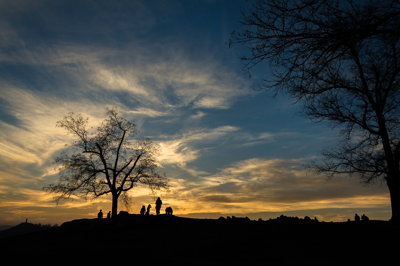 group of people on a mountain at sunrise